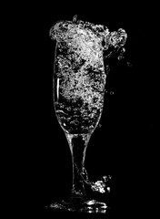 Splashes and drops of water in a glass are isolated on a black .