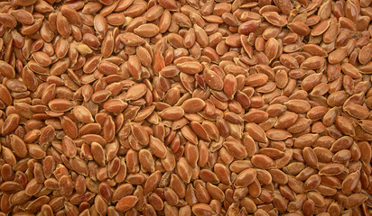 Flax seed is used to make linseed oil. Brown flax seed background.