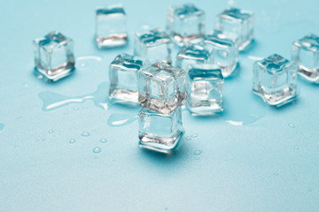 Ice cubes with water on a blue background. Ice concept for drinks. Banner. Flat lay, top view