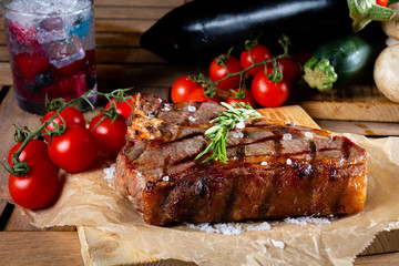 Grilled steak with vegetables, sea salt, rosemary and spices served on the restaurant table