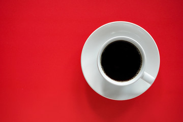 Cup of black coffee on red background  with copy space