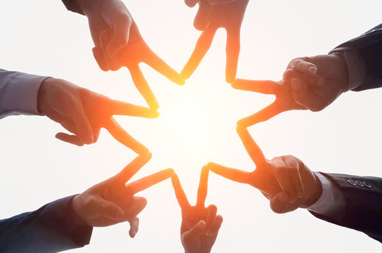 Close up image of successful team join  hands up   to the sky like star shape for achievement target ,collaboration and close relationship on isolated white background, sun light ,teamwork concept,