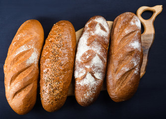 Many mixed breads and rolls shot from above. Top view of assortment of different cereal bakery