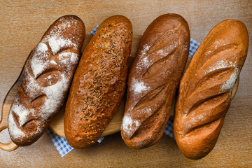Many mixed breads and rolls shot from above. Top view of assortment of different cereal bakery
