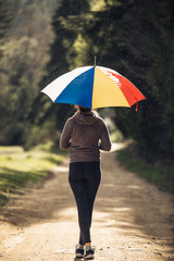 young woman with umbrella in the forest  in tha rainiy day.