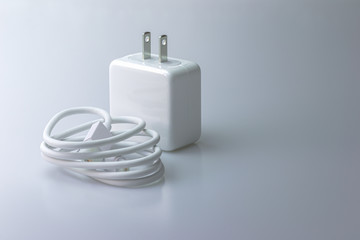 White electric charging with USB cable for phone on gray background