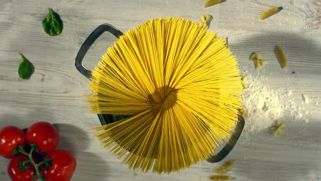 Throwing spaghetti pasta into water. Overhead shot. Top view. Shot with cinema camera RED DRAGON 240 fps. 4K. Slow Motion.