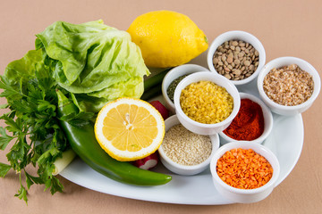Platter with spices, salad, lemon, paprika, pepper, rice, lentil