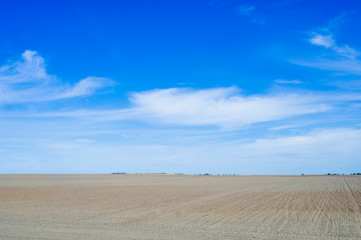Fototapeta na wymiar Plowed field against the blue sky