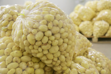 Raw potatoes in plastic bag