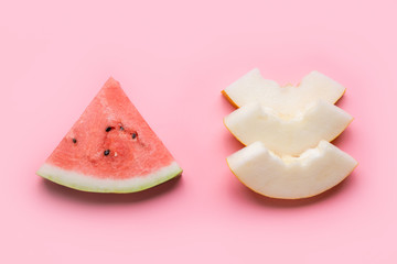 Sliced Watermelon and melon on pink. Compare and eating habits. Food concept. Flat lay.