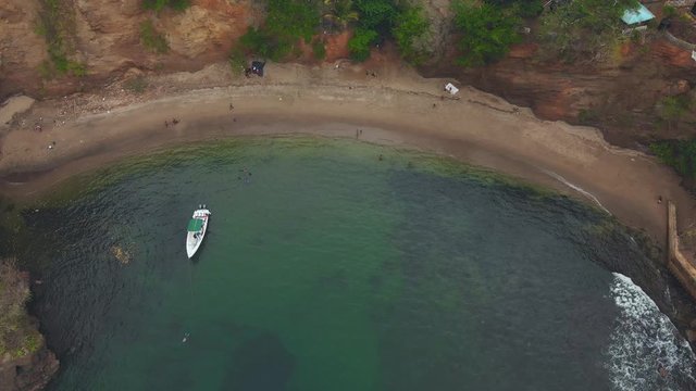 Descending aerial of a yacht anchored in a secluded bay at Monos island in the Bocas del Dragon region of Trinidad and Tobago