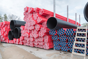 A lot of plastic pipes. Pipes of various colors and sizes. Warehouse, production, variety.