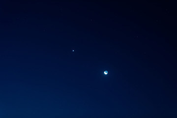 Young Moon and Venus on a dark night sky.