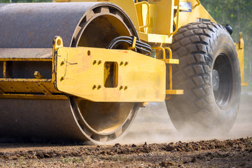 Close up of vibratory roller compactor working on construction site. Compaction machine on road...