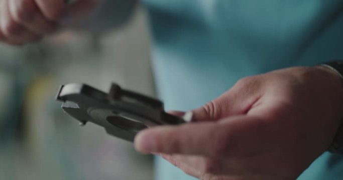 Close view of male hands measuring detail's hole size with calipers on a factory