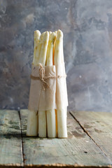 Freshly picked natural organic bunch of white asparagus vegetables on a wooden background.