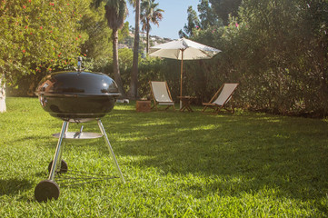 Summertime fun. Barbecue for summer family dinner in the backyard of the house.