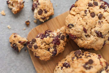 Fresh organic homemade cookies with chocolate chips and dried berries on wooden board on table