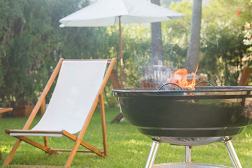 Summertime fun. Barbecue for summer family dinner in the backyard of the house.