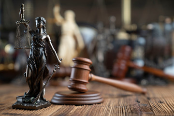 Fototapeta na wymiar Lawyers office concept. Law symbols composition - gavel and Themis statue on rustic wooden desk.
