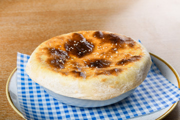 Kebab meat balls in a white bowl, served with a pita bread cover on top.