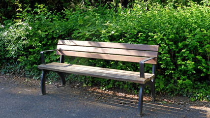 empty park bench with sun and shadow