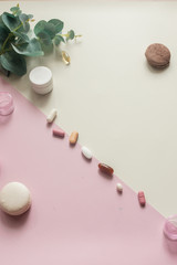 A close-up top view of various pills and macaroni on yellow and pink background.Medical, pharmacy and health care concept. Pill box. Dietary supplements and vitamins. Copy place for text or logo.