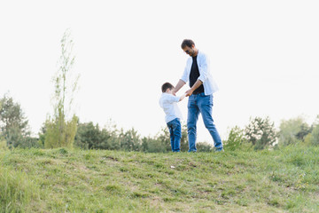 father and son have fun together in nature. Father and son playing. People having fun outdoors. Concept of friendly family.