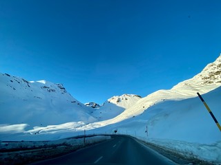 Fototapeta na wymiar Sankt Moritz (Schweiz) wunderschöne Berglandschaft mit Schnee und Bäumen im Winter bei Blauem Himmel in der Natur mit Felsen mit Sicht auf den Gipfel beim Skifahren mit Passstraße in den Alpen