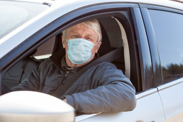 Senior man a driver using surgical mask to prevent virus infection, taxi driver