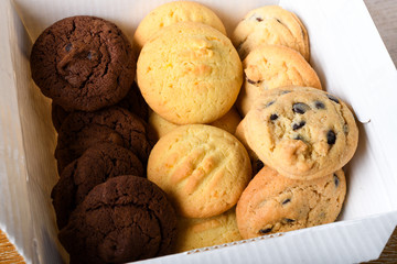 Homemade vanilla, orange, lemon chocolate chip cookies biscuits stack on a white plate