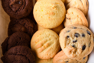 Homemade vanilla, orange, lemon chocolate chip cookies biscuits stack on a white plate