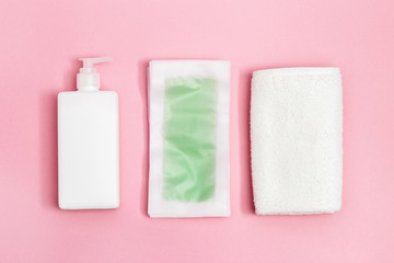 Set of female of hair removal. Wax strips, body moisturizer and white cotton towel on pink paper background with copy space. Top view. - obrazy, fototapety, plakaty
