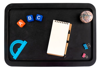 Back to school background with accessories for the schoolroom - notepad, globe, protractor, letters a b c on blackboard