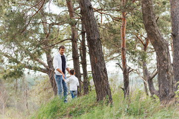 Naklejka na ściany i meble father and son have fun together in nature. Father and son playing. People having fun outdoors. Concept of friendly family.