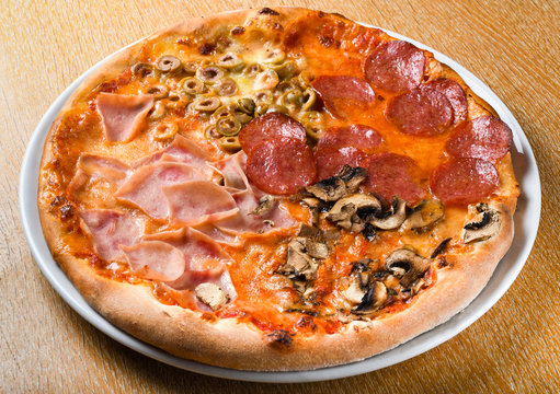 Pizza quattro stagioni is a variety of pizza in Italian cuisine that is prepared in four sections