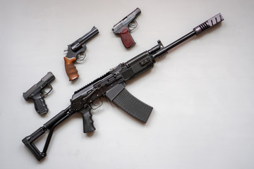 Close-up of a boar machine gun and pistol on a gray background. Isolated. flat lay.