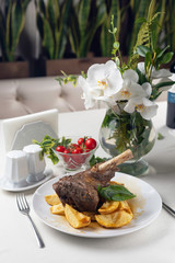 Grilled meat on a white plate in a served restaurant