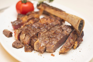Grilled meat on a white plate in a served restaurant
