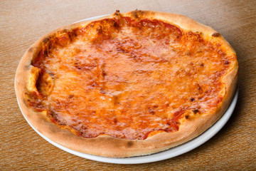 Pizza Margherita on brown table background, top view. Pizza Margarita with Tomatoes, mozzarella