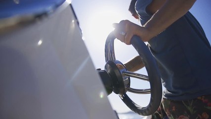 man on a summer holiday steering the wheel on small day boat during a summer holiday adventure on the ocean - Powered by Adobe