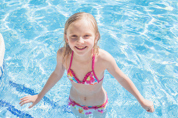 Summertime fun. Happy girl in pool in sunny day. Vacations.