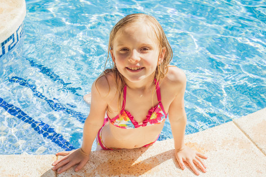 Summertime fun. Happy girl in pool in sunny day. Vacations.