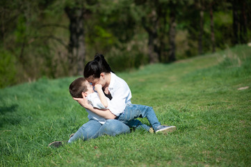 Stilish mother and handsome son having fun on the nature. Happy family concept. Beauty nature scene with family outdoor lifestyle. Happy family resting together. Happiness in family life. Mothers day.