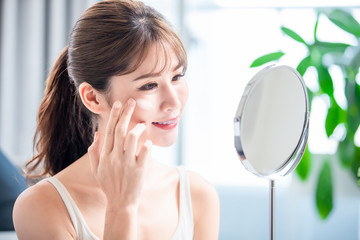 woman apply moisturizer on face