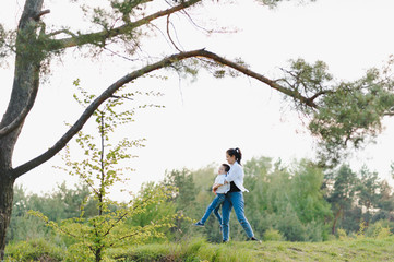 Fototapeta premium Stilish mother and handsome son having fun on the nature. Happy family concept. Beauty nature scene with family outdoor lifestyle. Happy family resting together. Happiness and harmony in family life.