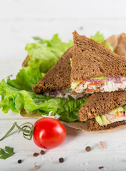 Club sandwich with chiken and cucumbers on dark rye bread