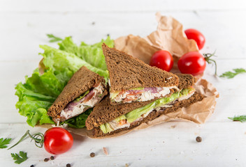 Club sandwich with chiken and cucumbers on dark rye bread
