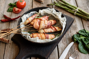 Roll with bacon and chicken mince on a stew with fresh asparagus